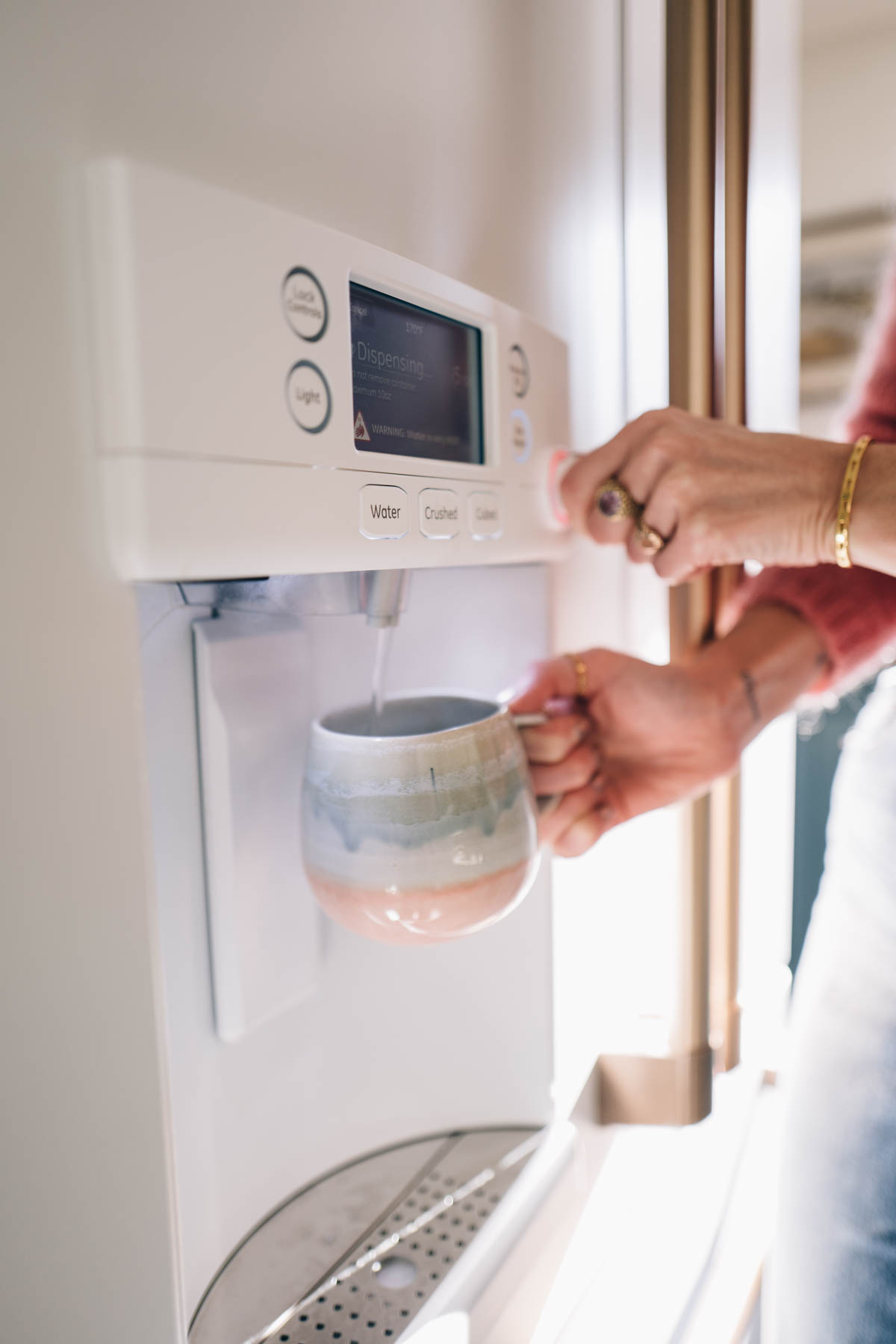 Jess Ann Kirby uses the hot water dispenser in her new Cafe Appliances fridge for morning tea