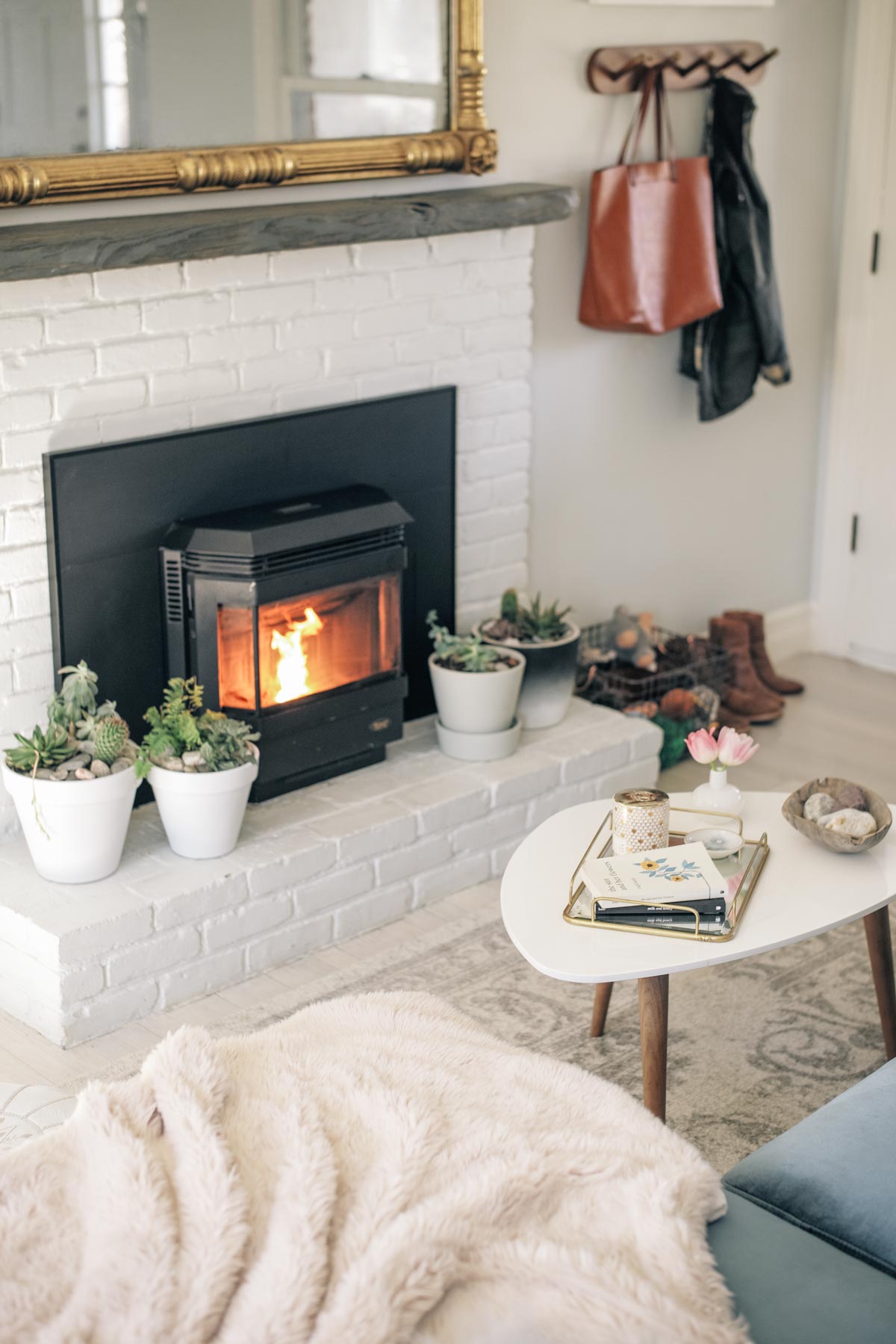 Jess Ann Kirby's home renovations includes a white brick mantle and pellet stove