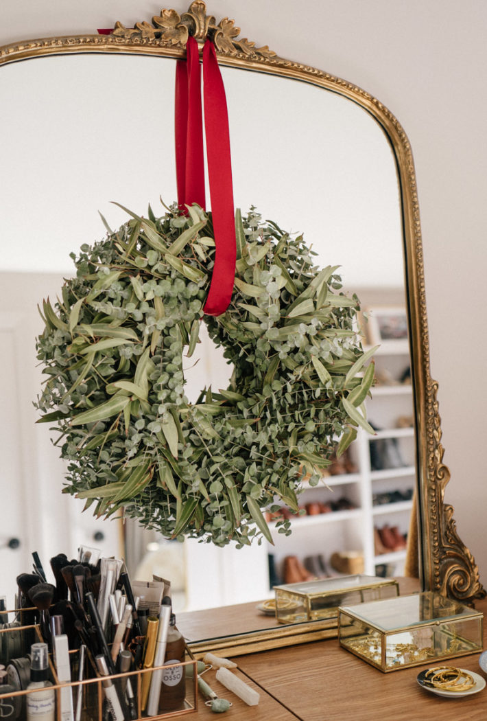 Jess Ann Kirby shares simple holiday decorating tips with the West Elm Eucalyptus wreath over her Anthropologie mirror