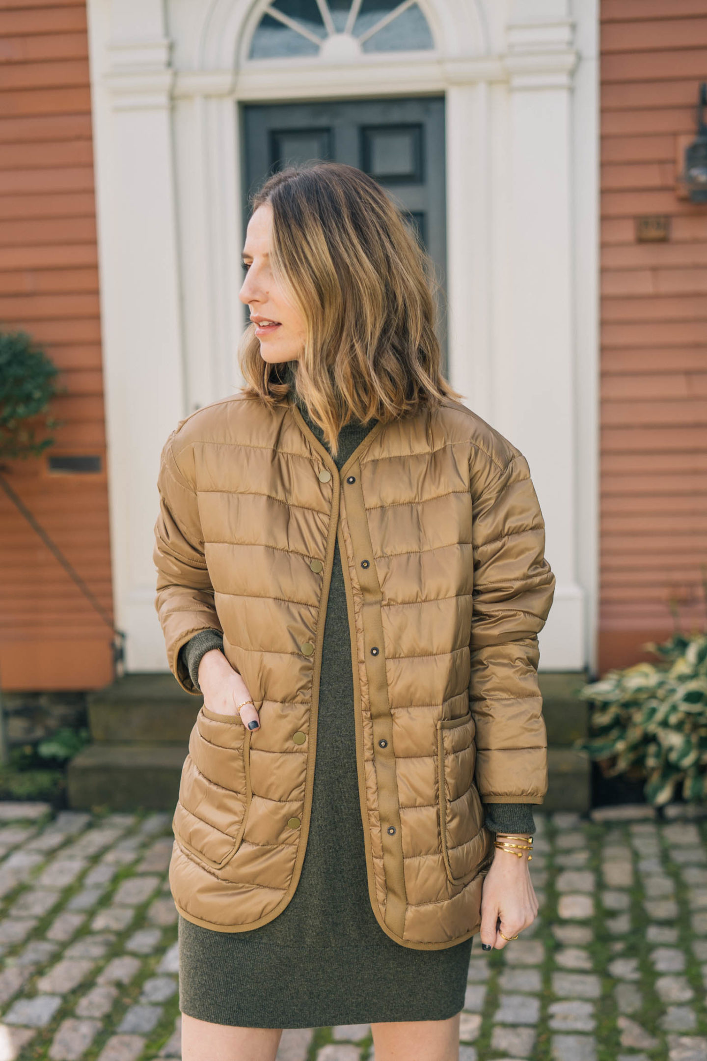 Jess Ann Kirby styles a lightweight puffer from Everlane with a sweater dress and booties.