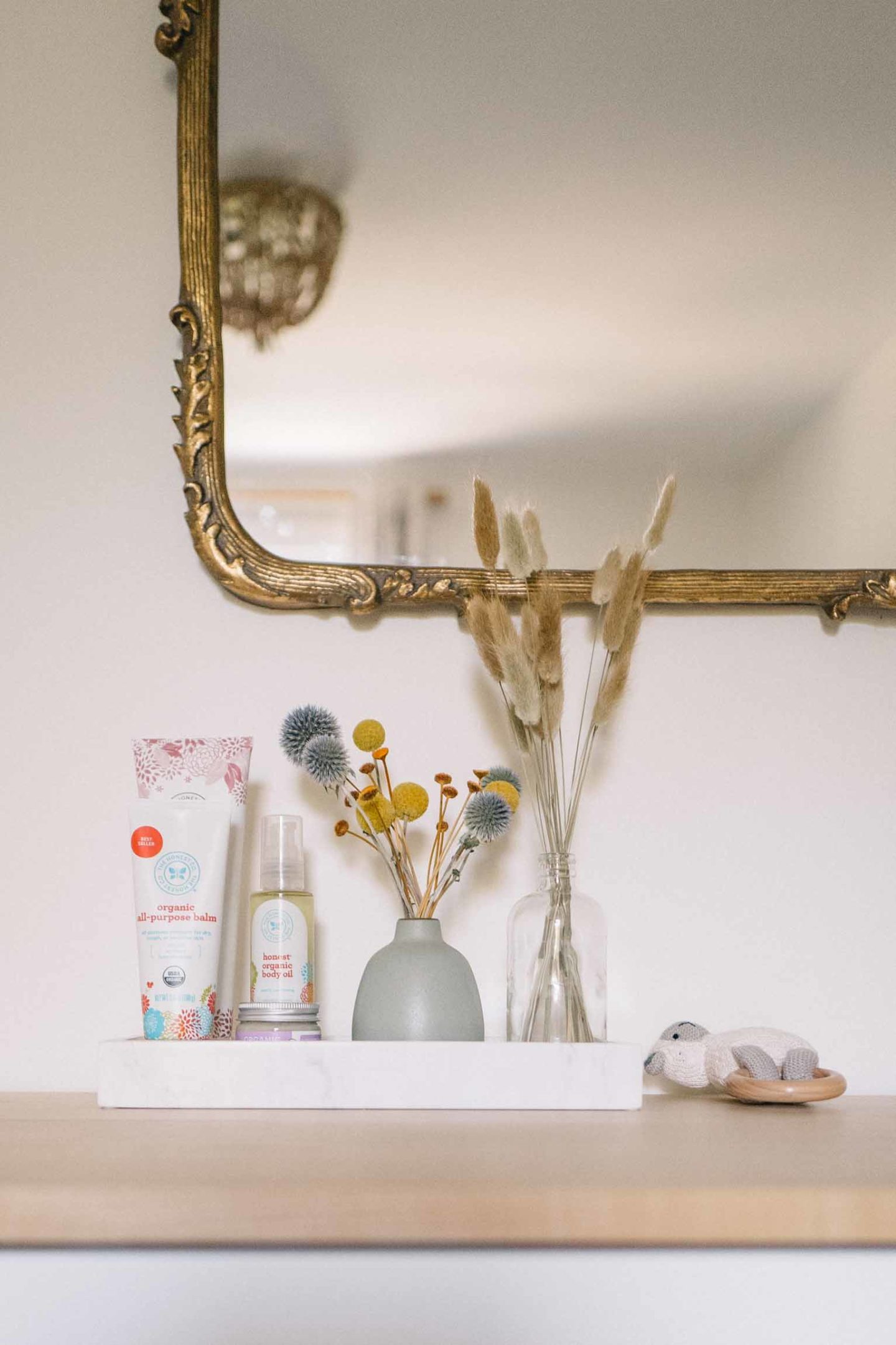 Jess Ann Kirby's nursery vanity is styled with dried flowers and clean baby products.
