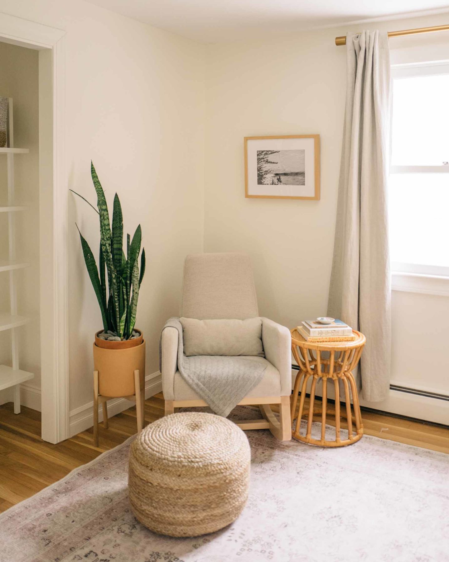 Jess Ann Kirby's reading nook in her new nursery is styled with a soft ottoman and tall planter.