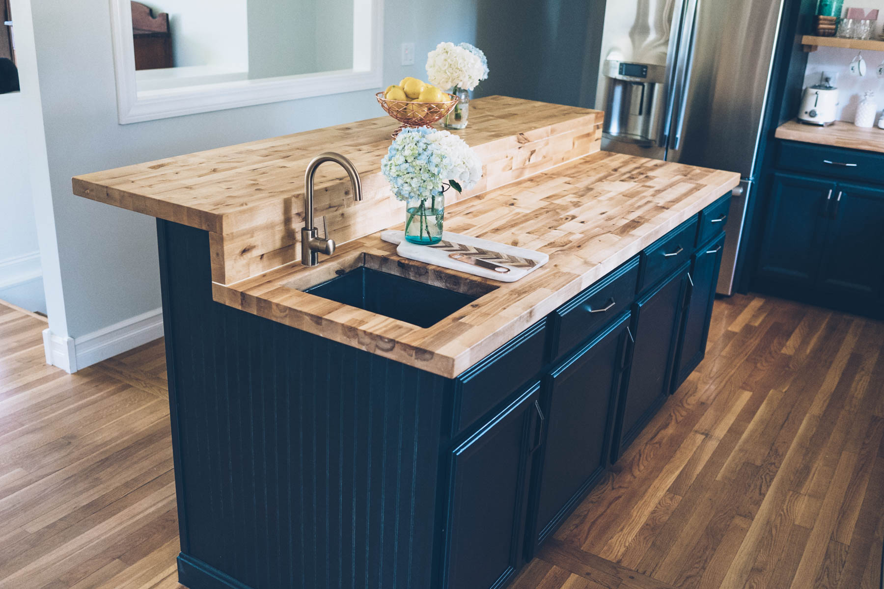 Jess Ann Kirby's kitchen renovation with Lowes. New butcher block countertops with delta faucet and dark green chalk painted cabinets